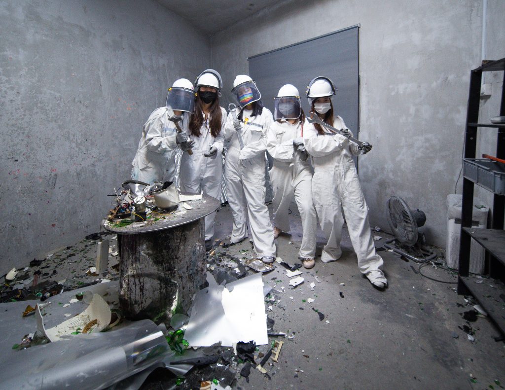 group of friends posing in smash room wearing protective clothing