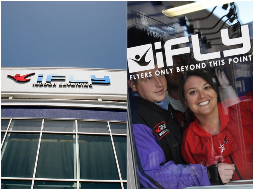facade of ifly building and two people in blue and red jumpsuits behind a glass door ready to indoor skydive