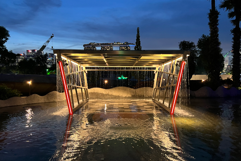 drone racing checkpoint and drone racing through sculpture over water lit up with red led lights in singapore with marina bay sands visible in the background