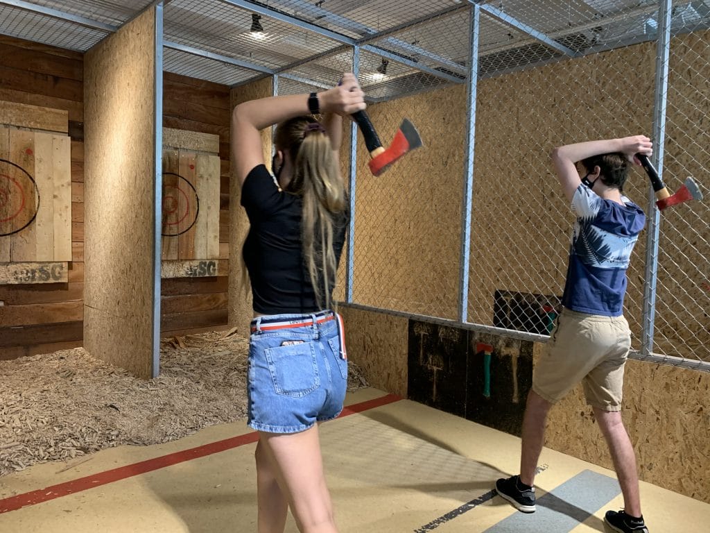 woman and man throwing axes
