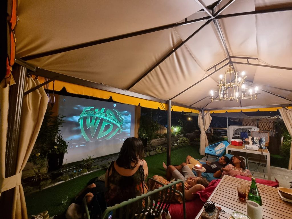 group of people watching a film on a projector on a rooftop