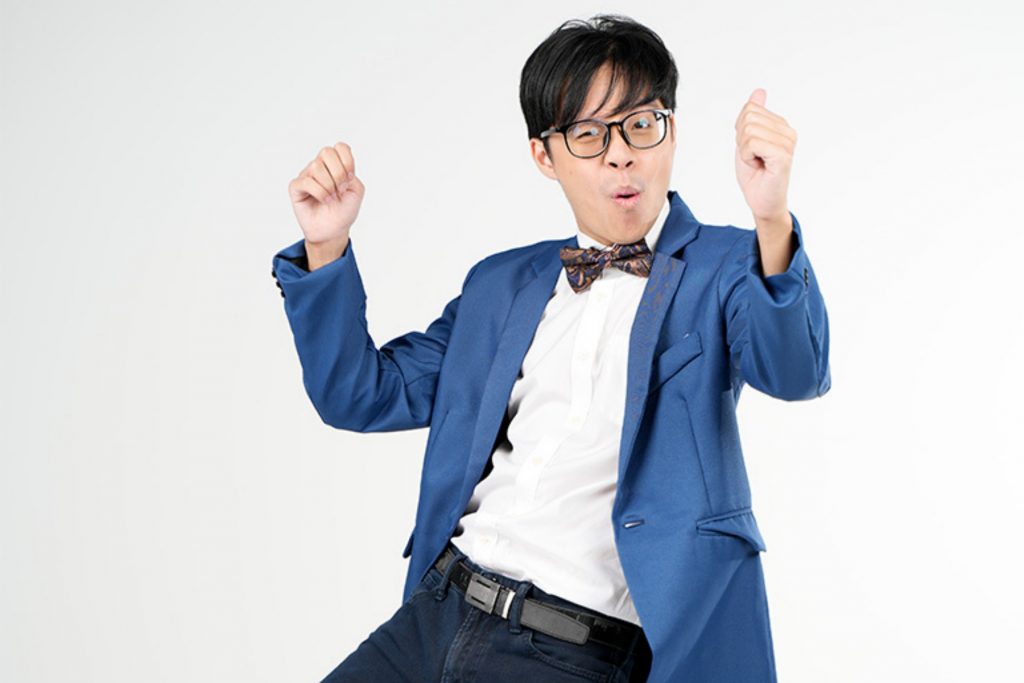 promo shot of comedian sam see in blue jacket, white shirt, from waist up