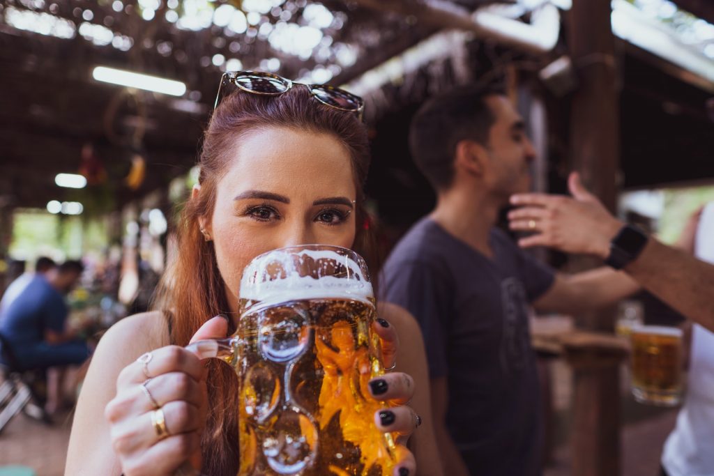 young woman drining a stein of beer